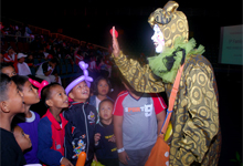 A clown entertaining the excited children with his tricks.